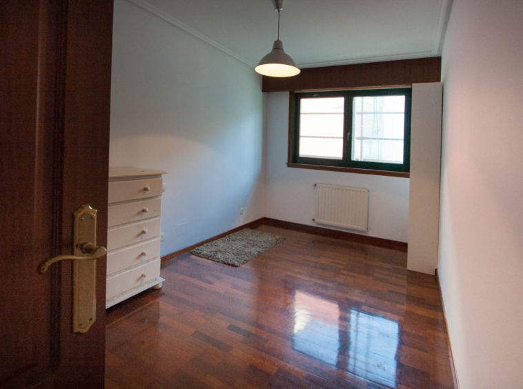 Dormitorio vacío previo al Home Staging en piso Sada_ cómoda blanca y estantería