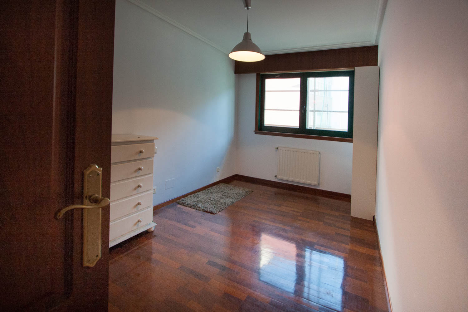 Dormitorio vacío previo al Home Staging en piso Sada_ cómoda blanca y estantería