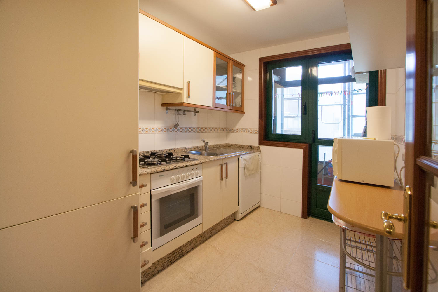 Cocina clásica beige piso Sada con carpintería de pvc verde para acceso a lavadero tendedero_ foto previa