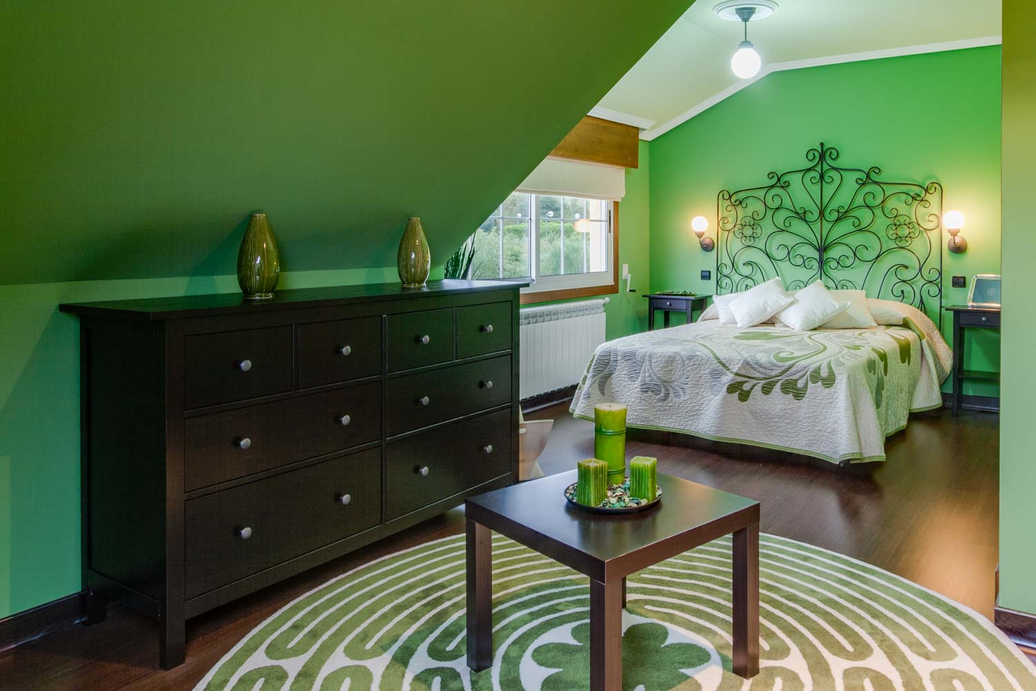 Dormitorio decorado en verde con cama de matrimonio y cómoda