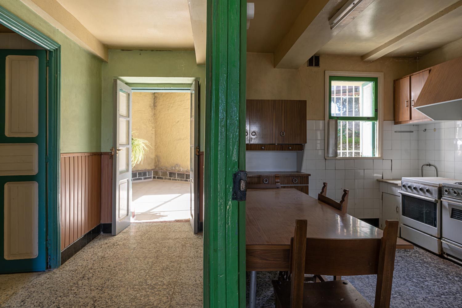 Fotografía de casa para reformar en Bergondo con carpinterías verdes_cocina, deistribuidor y acceso a zona exterior