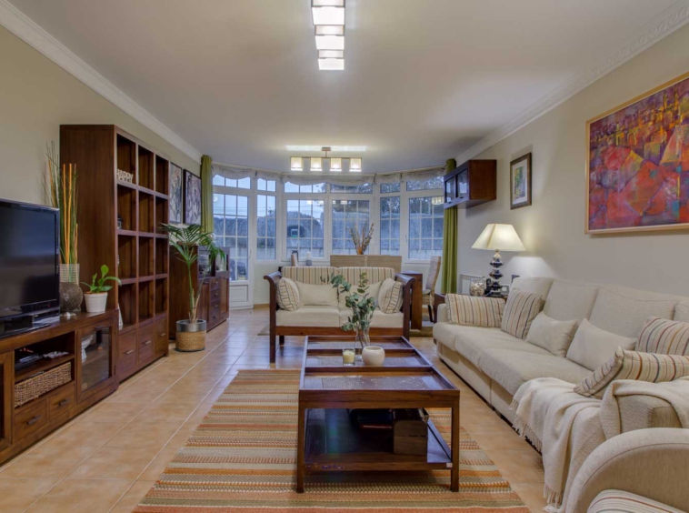 Salón con muebles en madera y conjunto de sofás en color crema