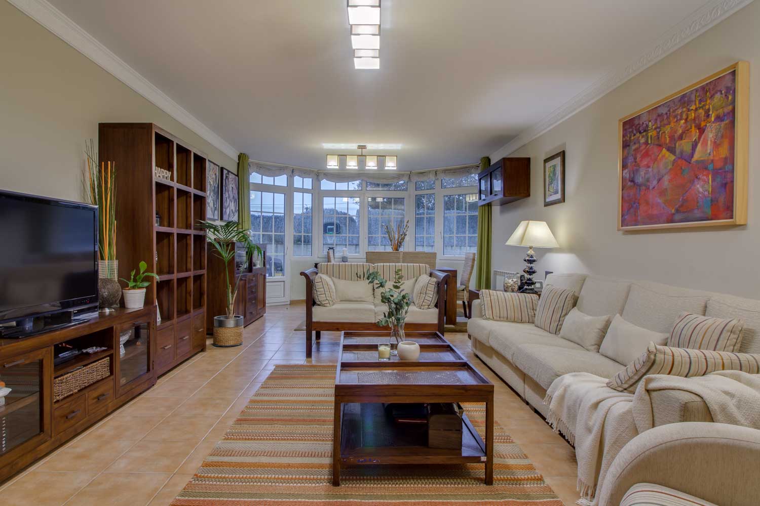 Salón con muebles en madera y conjunto de sofás en color crema
