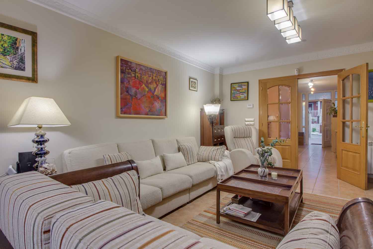 Detalle de sofás y butaca en color crema del salón