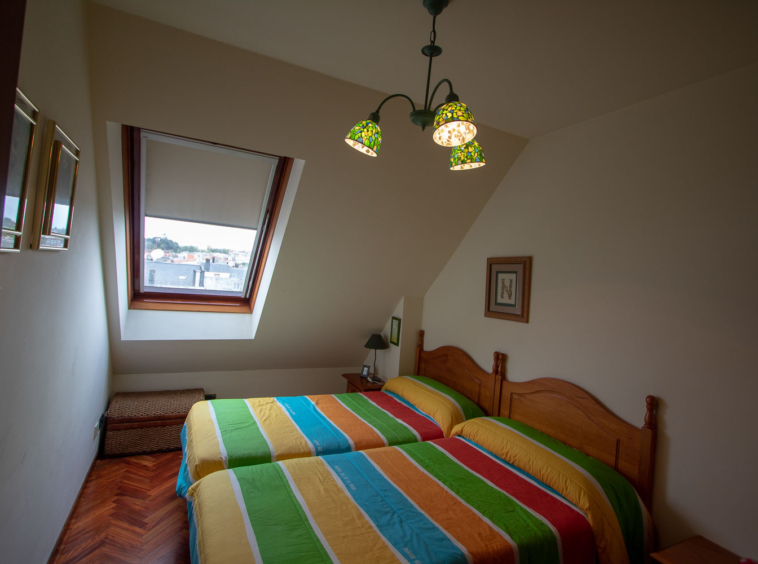 Dormitorio con camas gemelas y ventana velux