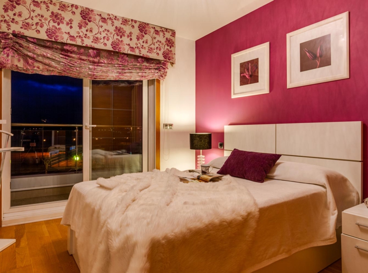 Dormitorio pintado en burdeos y crema, con cama y cabecero