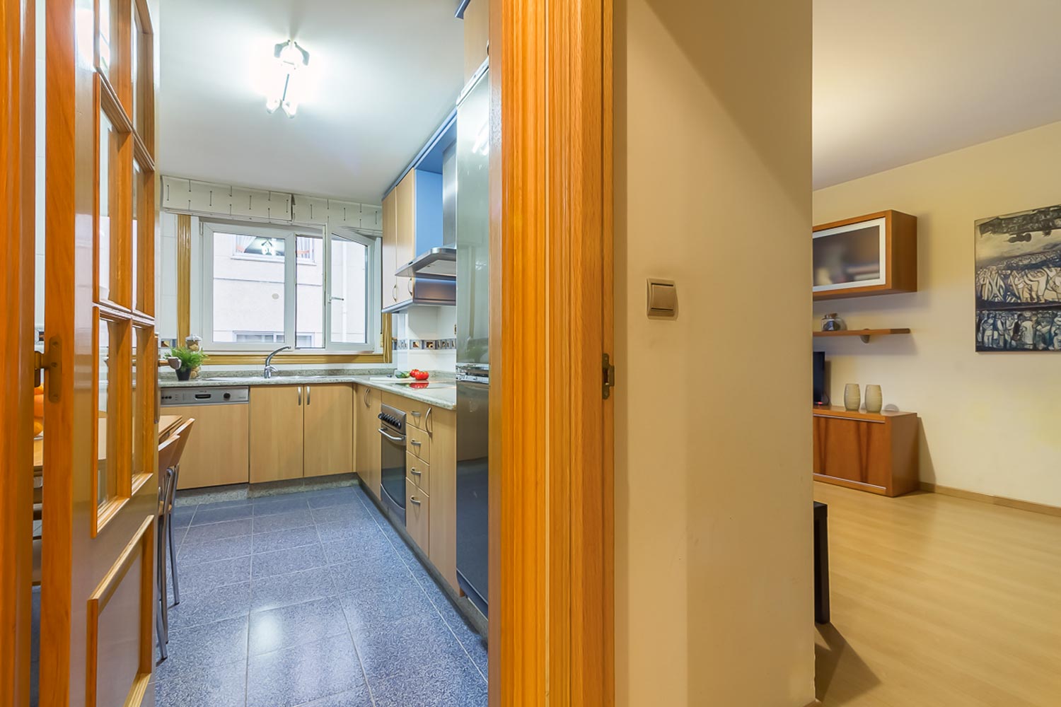 Cocina con suelo de azulejo azul y frontales de madera clara_ conexión con salón_home staging
