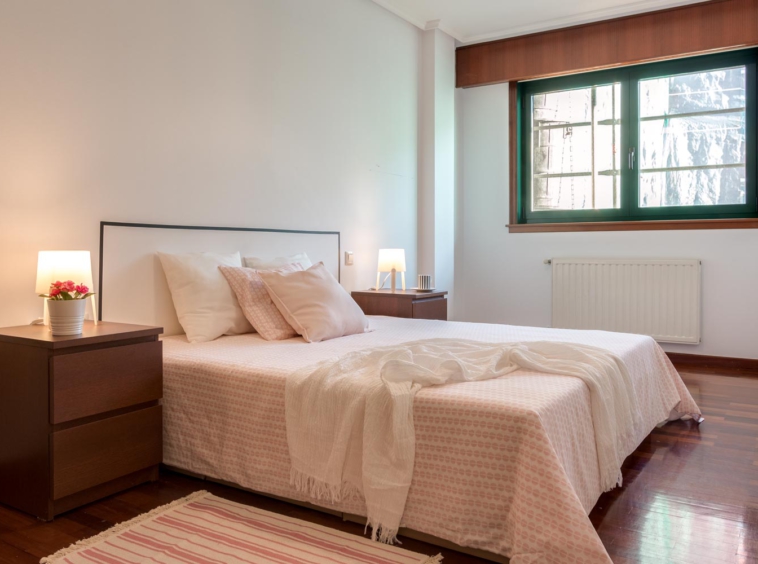 Dormitorio doble con cabecero de vinilo en pared y textiles blancos y rosa palo_ carpintería verde