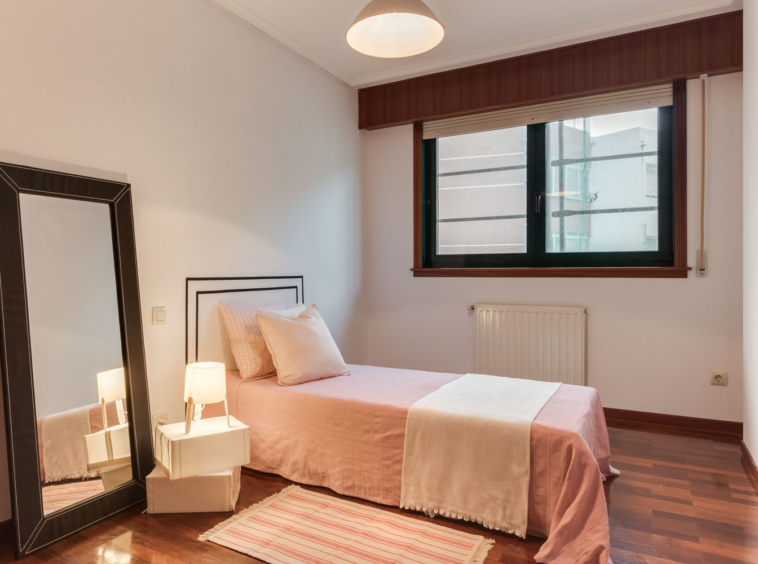 Dormitorio doble con cabecero de vinilo en pared y textiles blancos y rosa palo_ carpintería pvc verde