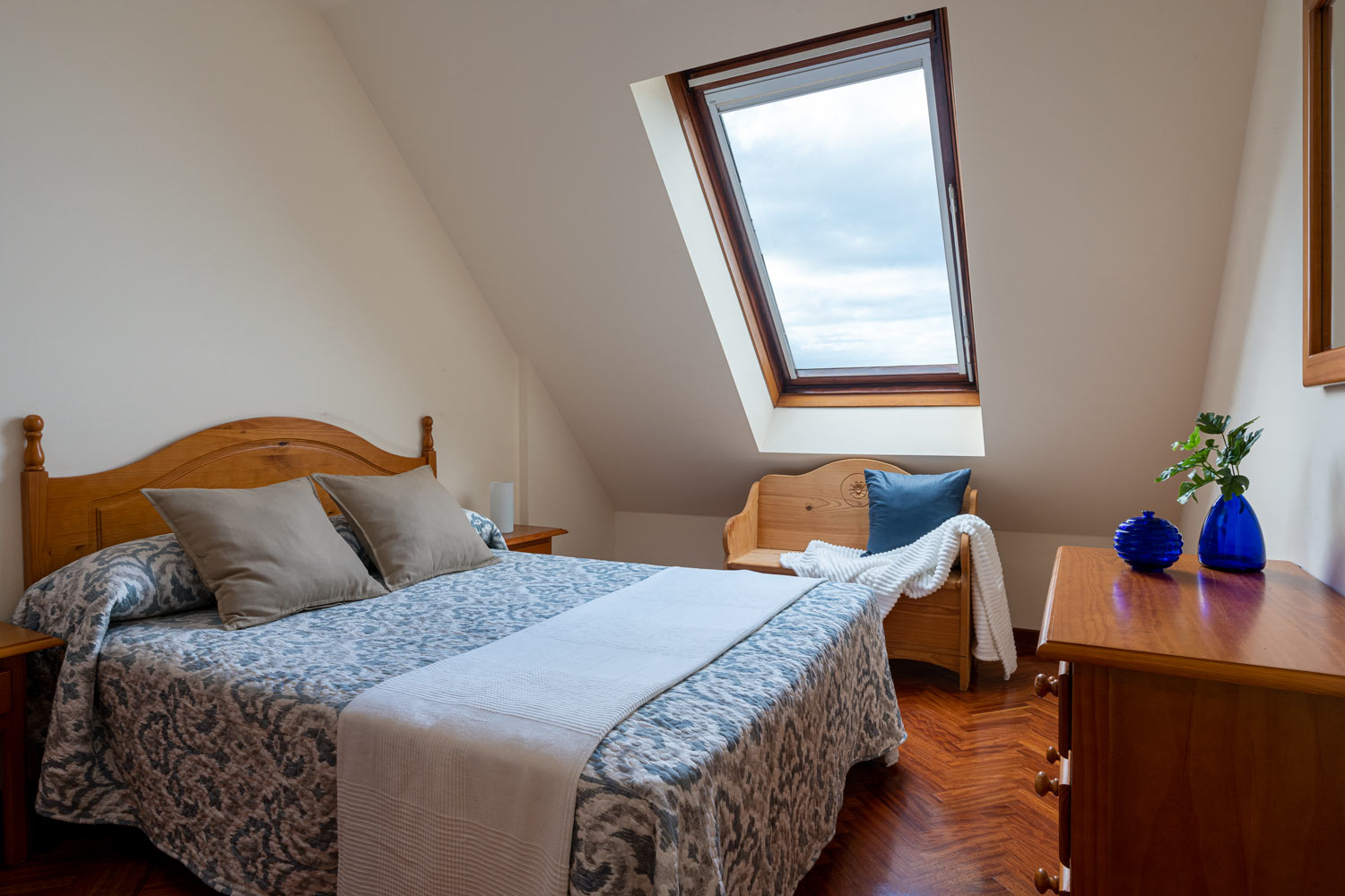 Dormitorio principal con cama de matrimonio y ventana velux