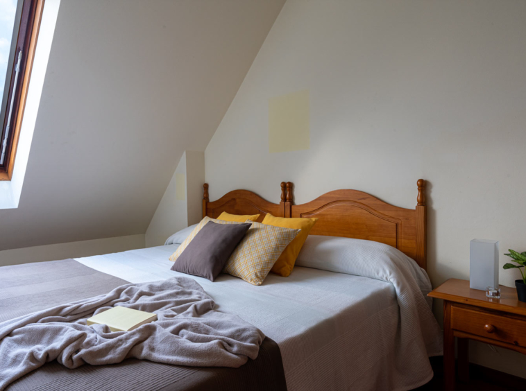 Dormitorio con camas gemelas y ventana velux