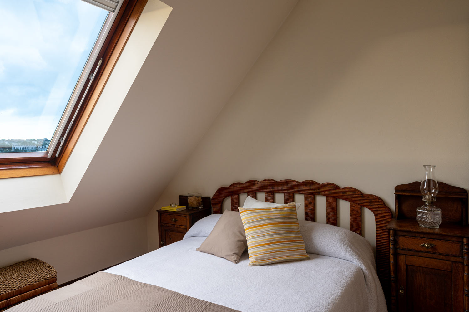 Dormitorio con cama invididual y ventana velux