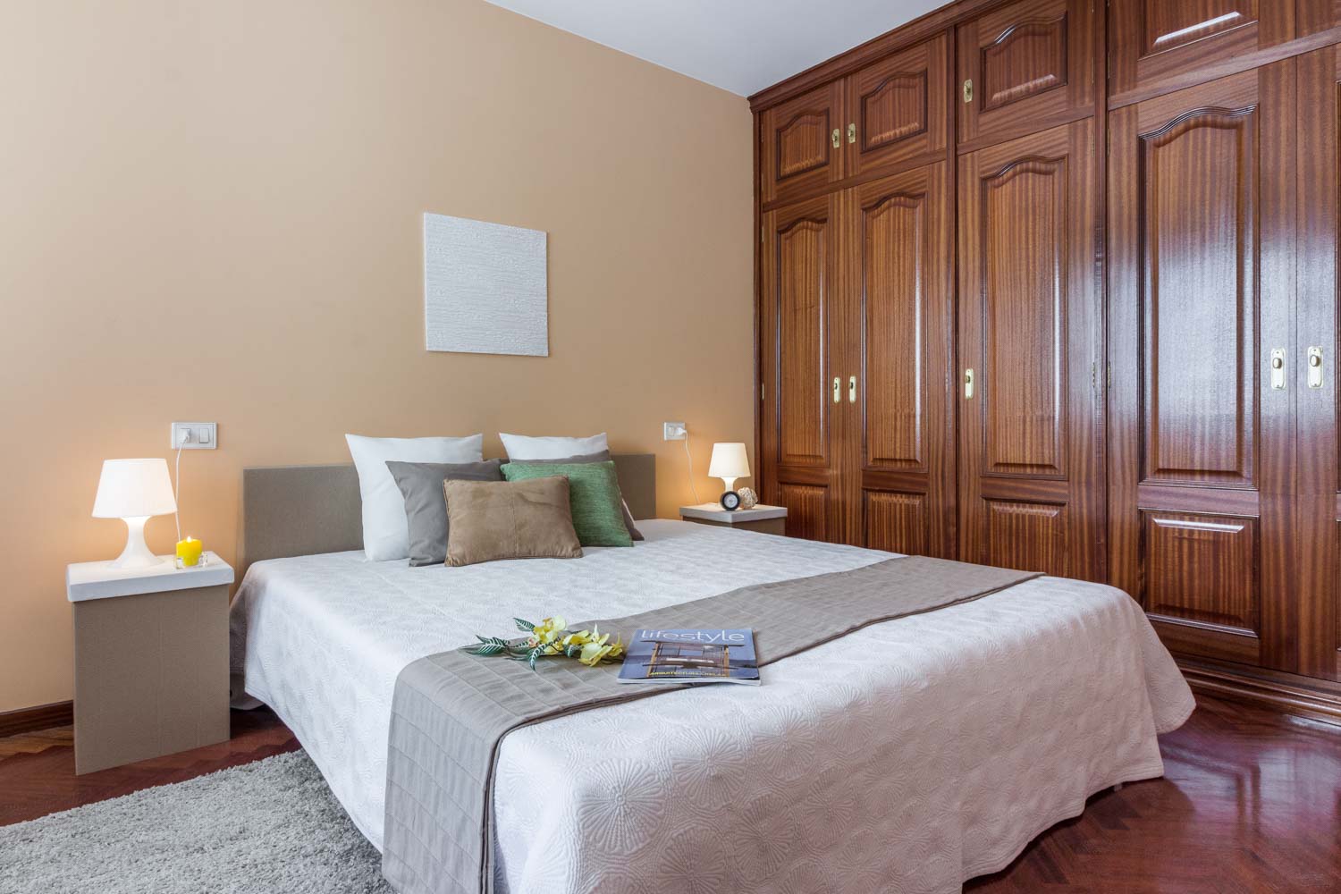 Dormitorio principal con home staging de cartón y textiles neutros_armario empotrado grande de madera