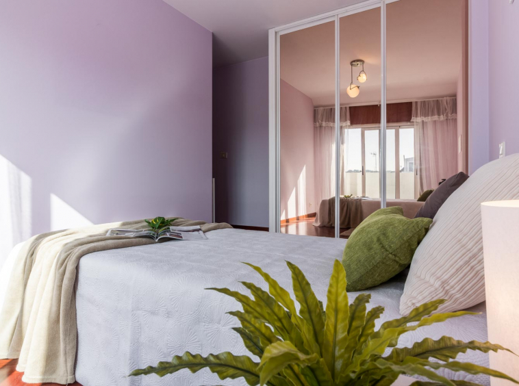 Dormitorio morado decorado con tonos neutros verdes_ armario empotrado con espejo