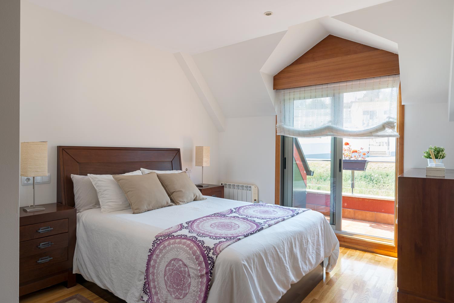 Dormitorio principal abuhardillado con salida a terraza_colores neutros y madera oscura de lineas puras