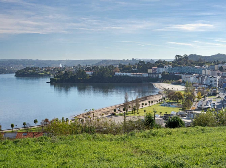 Vista panorámica de Sada, A Coruña, con playa y paseo marítimo bajo cielo azul, perfecta para proyectos de construcción residencial