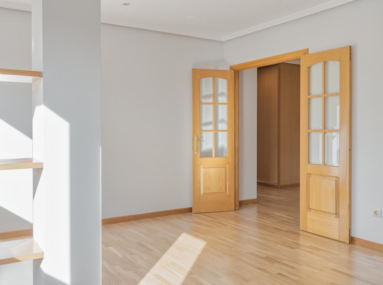 Salón con suelo de parquet y puerta con vidrio en piso en Sada, ideal para una decoración que fluya libremente