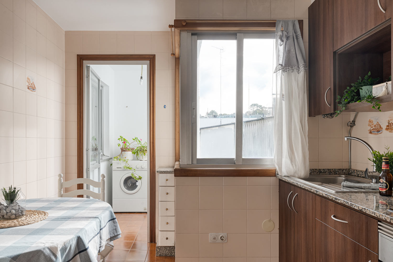 Cocina equipada con electrodomésticos modernos y ventana grande que proporciona luz natural, en un piso en venta en Sada, A Coruña