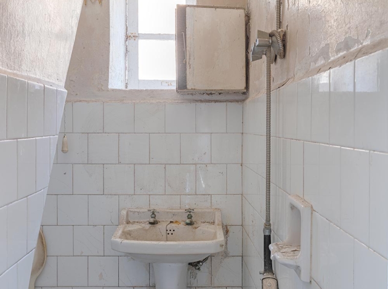 Baño con azulejos en blanco para restaurar en una casa en Sada