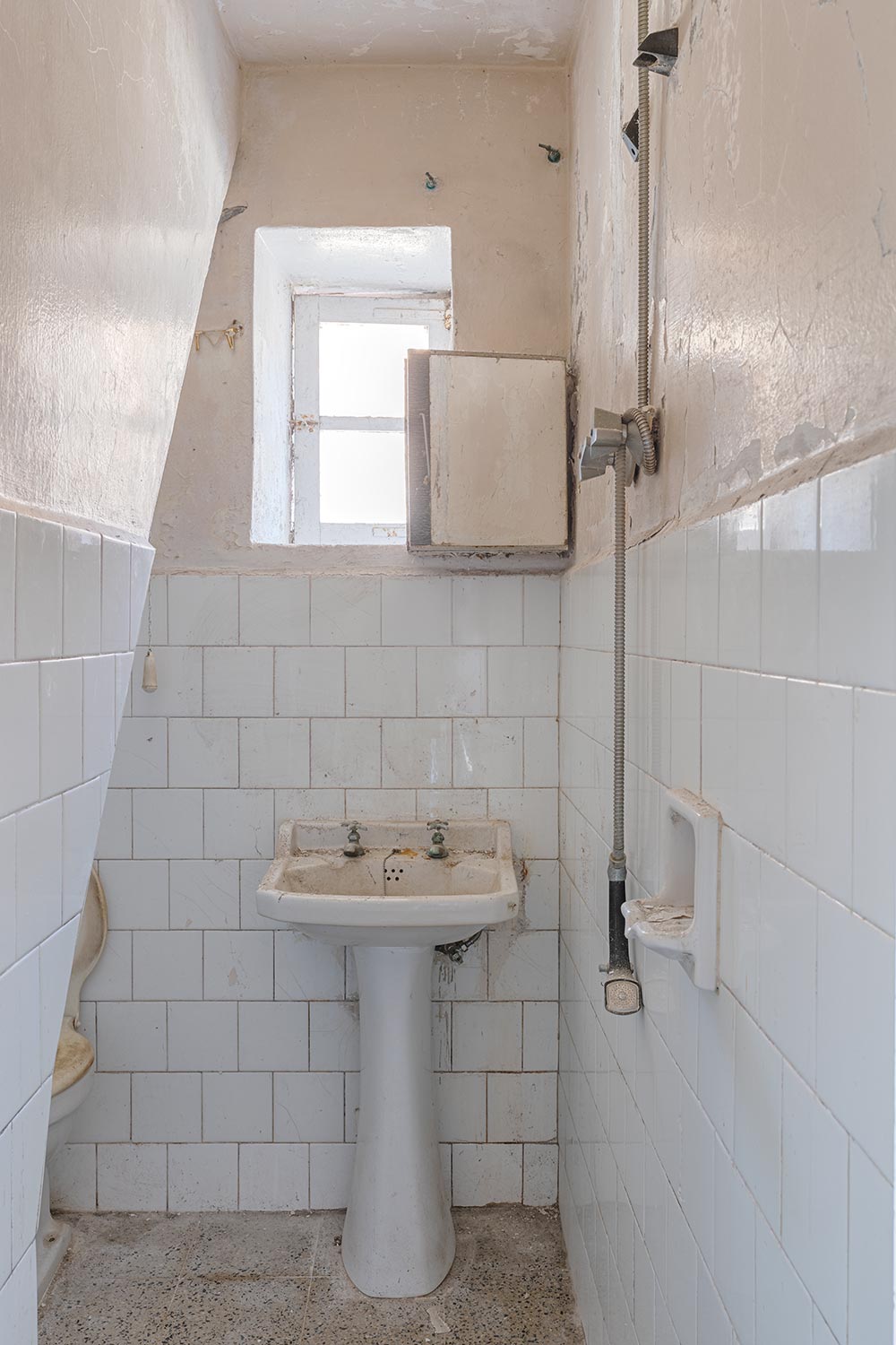 Baño con azulejos en blanco para restaurar en una casa en Sada