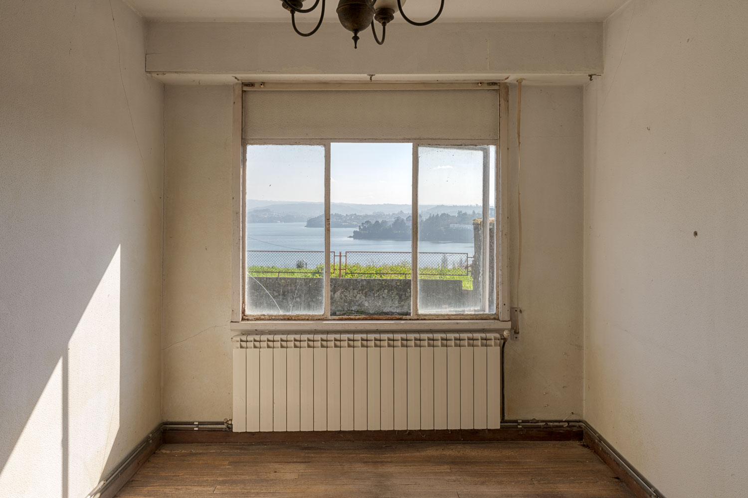 Habitación con ventanal por donde se pueden ver vistas al mar a la ría de Sada.