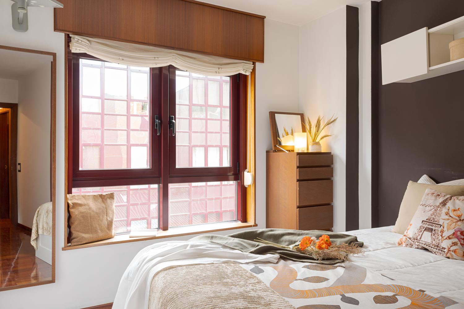 Dormitorio con gran ventanal en aluminio granate y paredes en tono marrón chocolate, con cama. Habitación preparada con Home staging